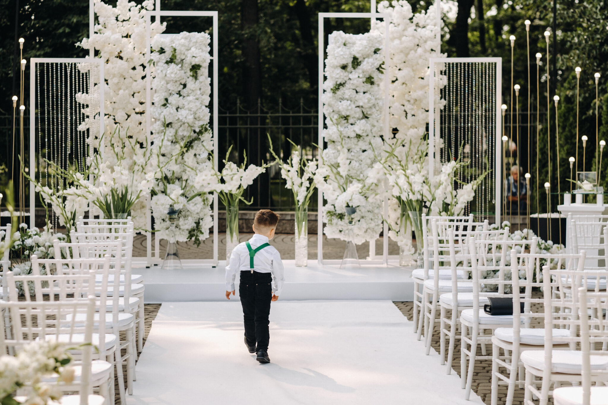 A place for a wedding ceremony on the street and a boy walking along the path. Decorated wedding venue.